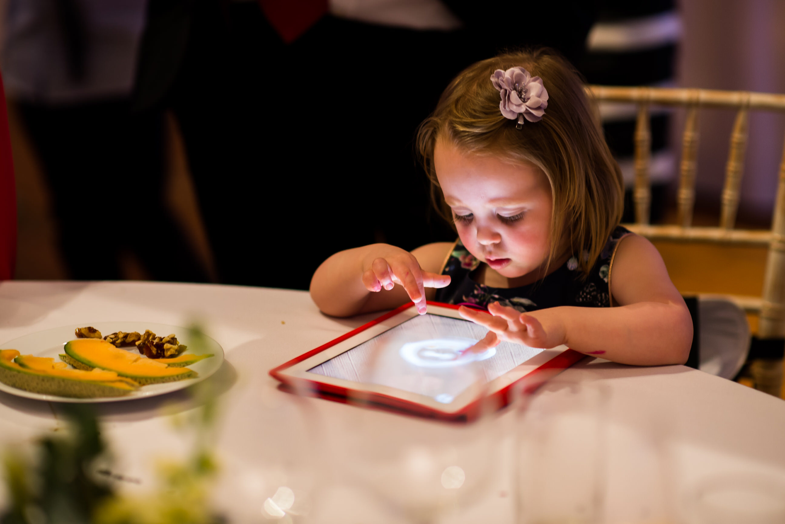 Girl playing on tablet at wedding 
