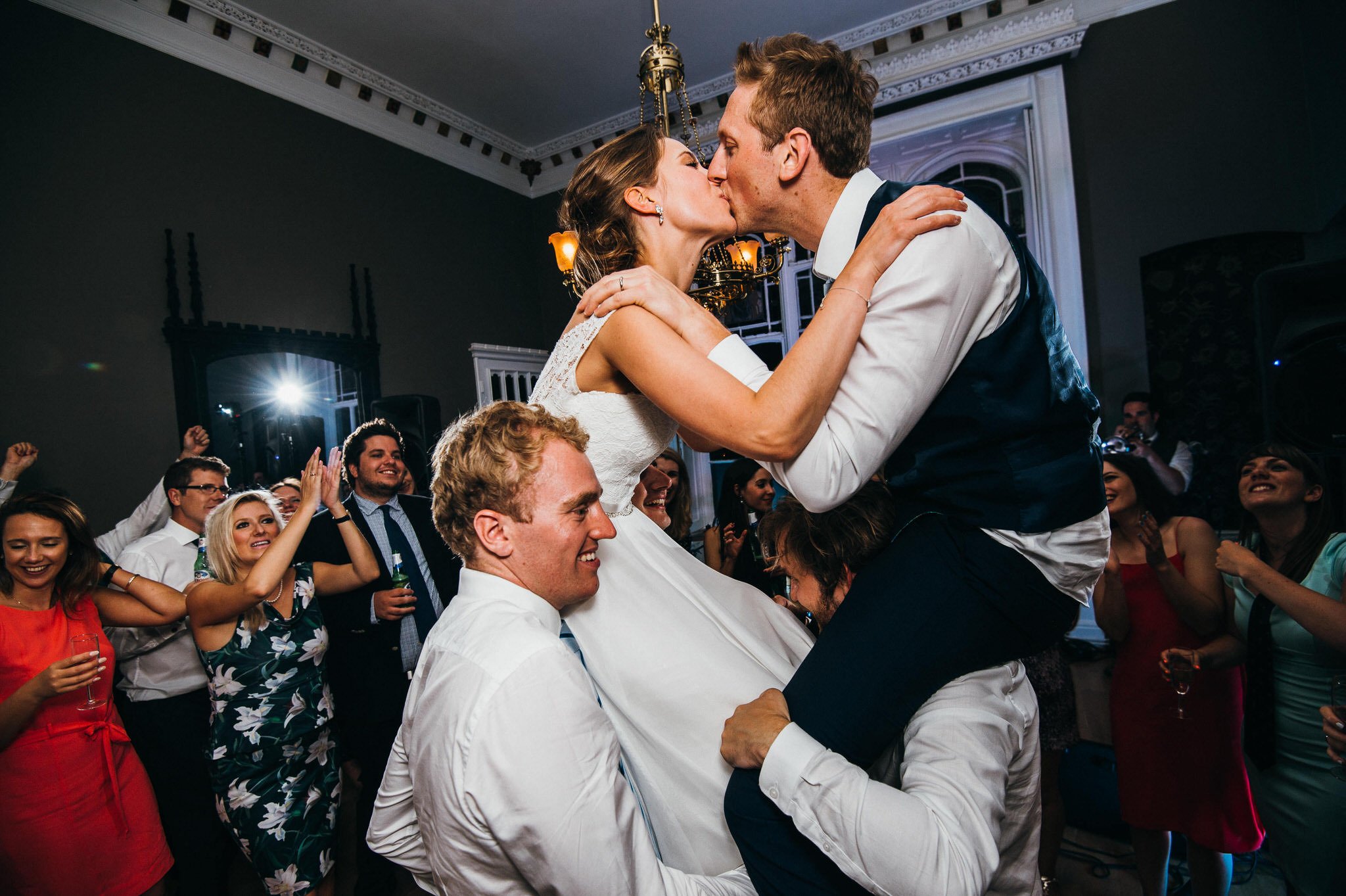 bride and groom on shoulders kissing 