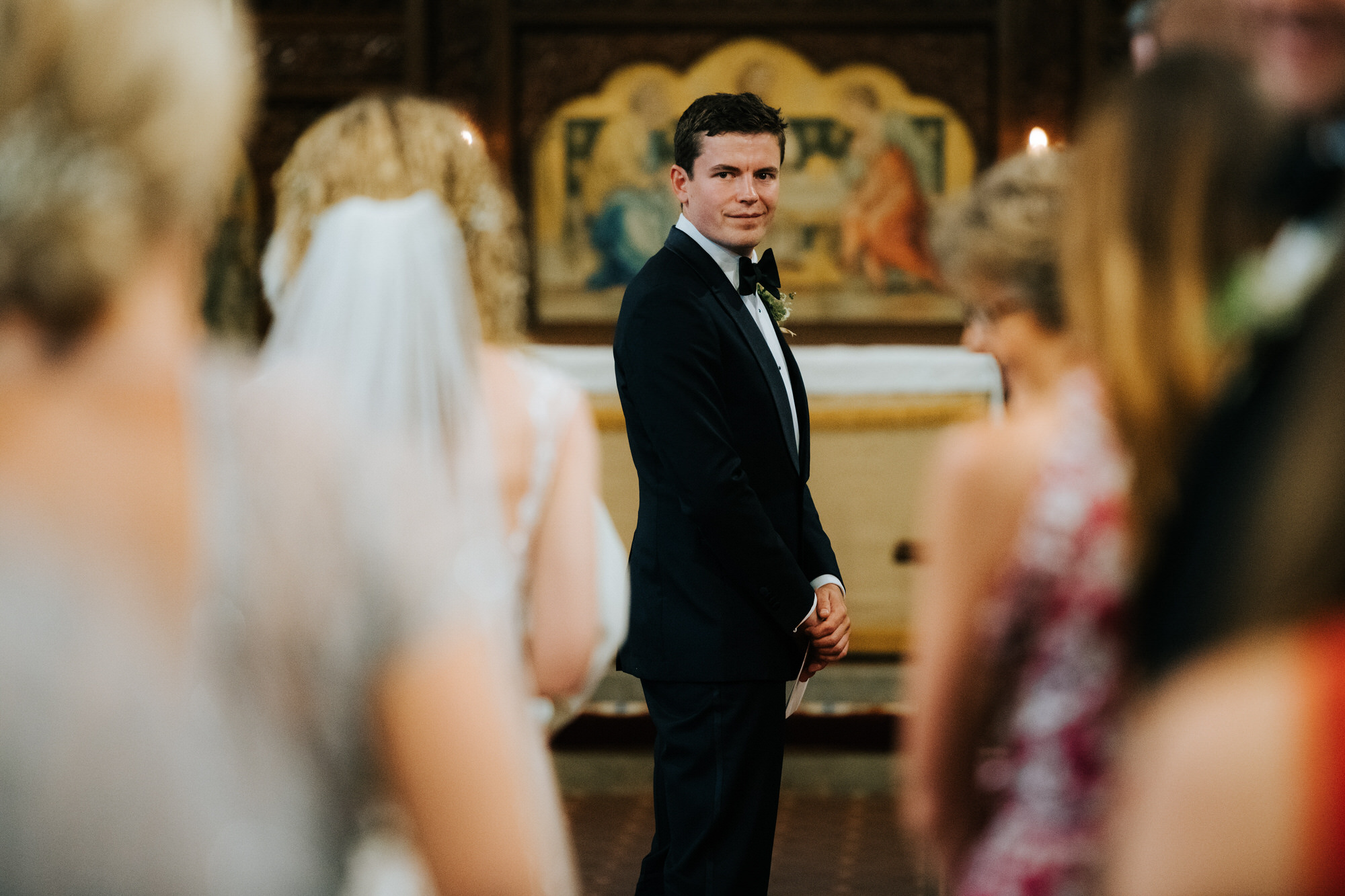 Groom looks back as bride walk down aisle in church 