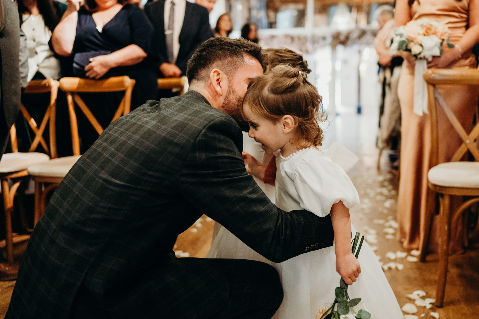 Groom cuddles his twin girls during start of wedding ceremony at Bury Court 
