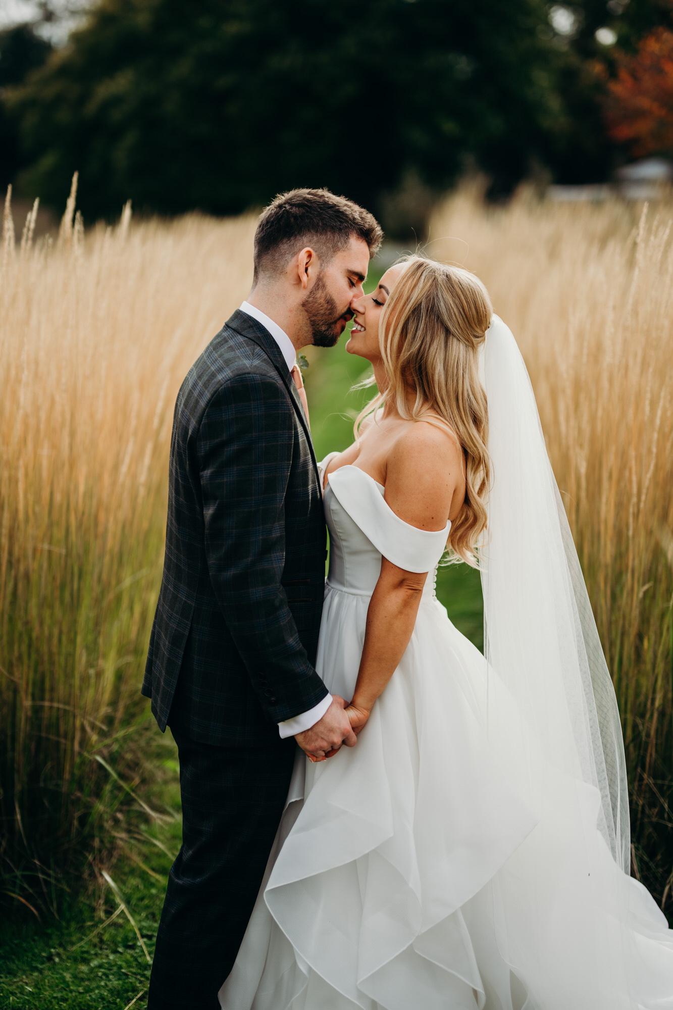 Bride and groom together during golden hour portraits at Bury Court Barn, with soft autumn light behind them.