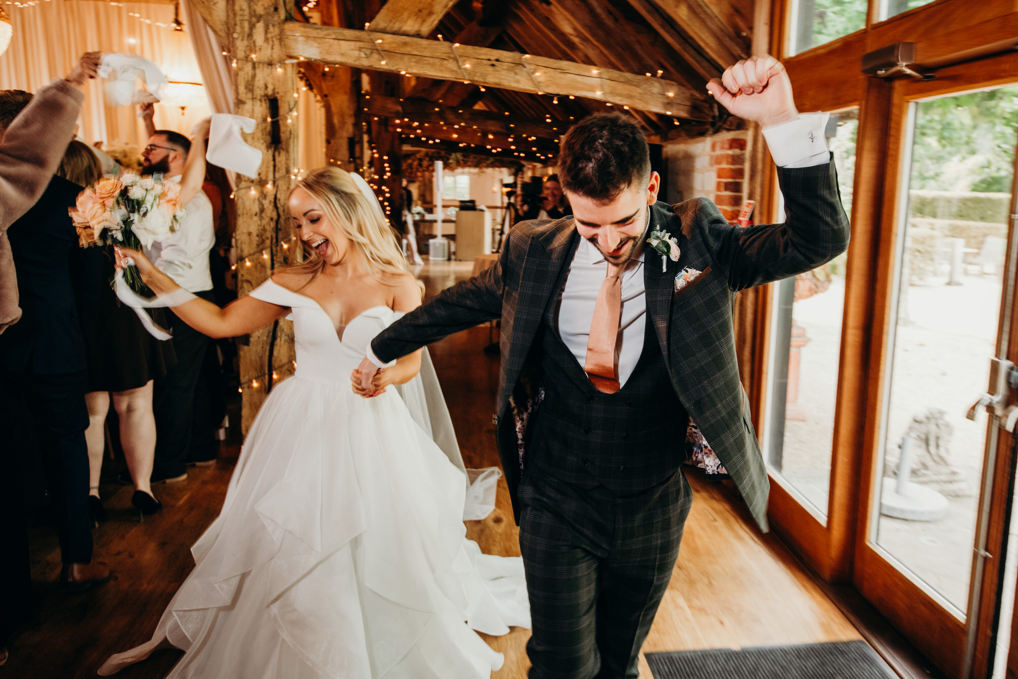 Bride and groom enter to napkin waving at Bury Court 
